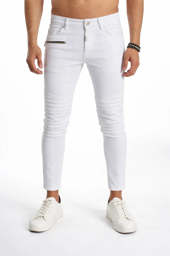 White slim-fit jeans with ribbed detailing, paired with white sneakers, worn by a model.