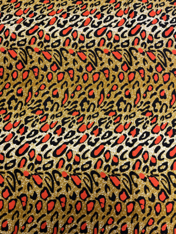 A piece of fabric with a animal print pattern in colors brown, orange, cream, and black.