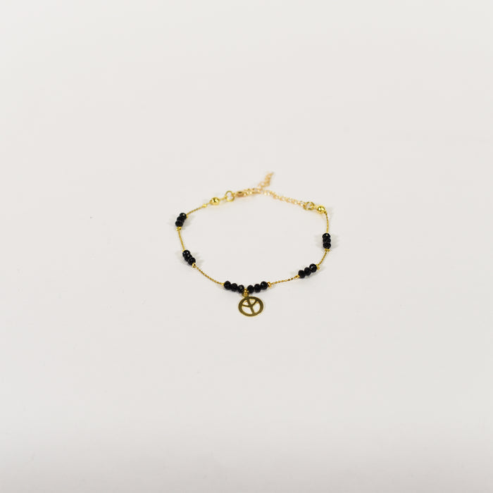 Golden curb chain anklet with black beads and peace sign charm, minimalist summer jewelry for women.