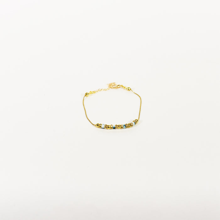 Dainty gold chain anklet featuring blue and white beaded charms on a minimalist adjustable link strand.