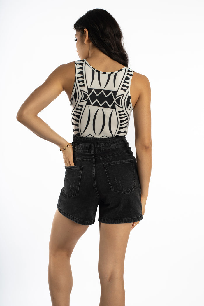 Back view of Anya white sleeveless bodysuit with black geometric print, styled with high-waisted black denim shorts.