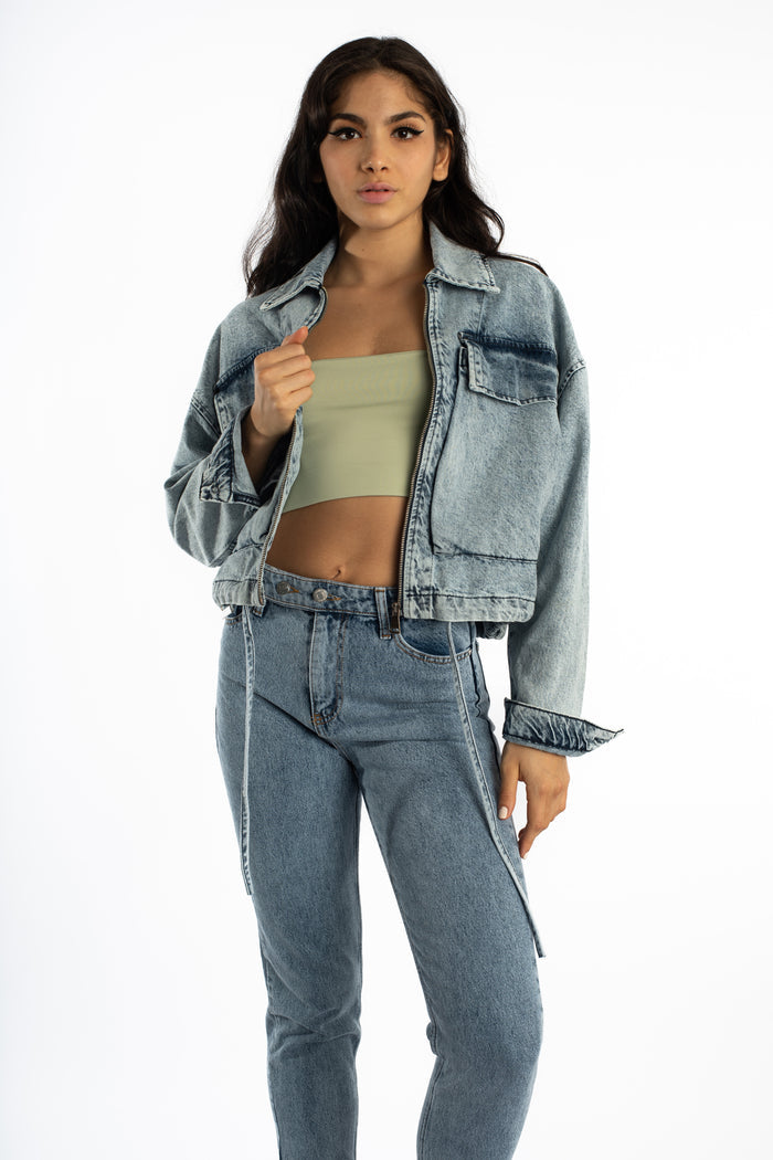 Model wears the oversized Aubri Blue Washed Denim Jacket with a zip front and streetwear-style pockets against white.