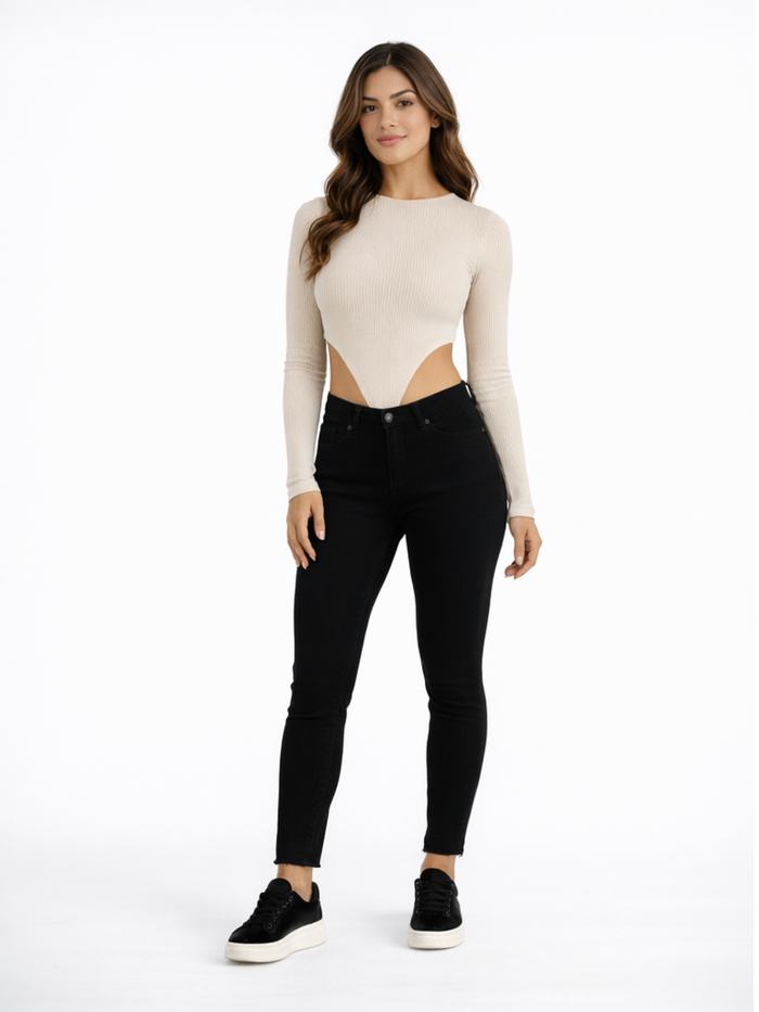 A model poses in a fitted ribbed top with cut-out sides, paired with black skinny jeans and sneakers.