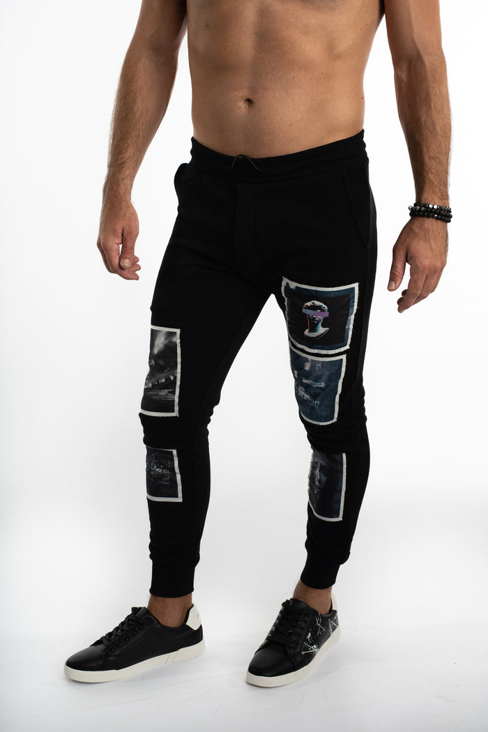 Men's black distressed joggers with graphic blind frame patches in a slim-fit streetwear style.