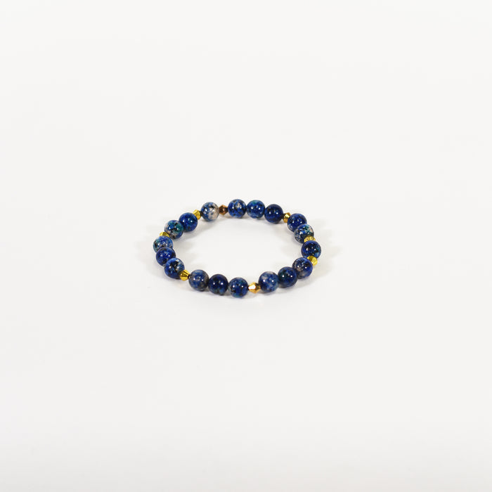 Blue beaded stackable bracelet with natural stone texture and gold accents for streetwear aesthetic on white background.