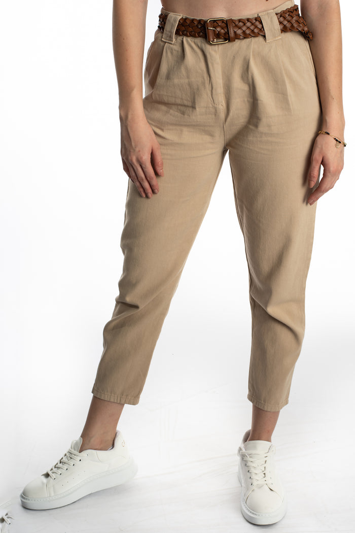 Model wearing Camryn high-waisted beige trousers with a brown braided belt and white sneakers.
