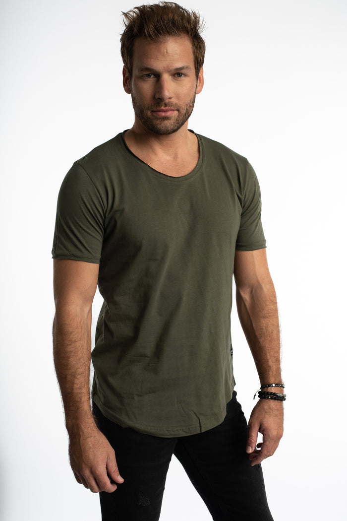 Men's Carbon Classic Streetwear Tee in olive green with a raw-edge scoop neck and curved hem on a studio model.