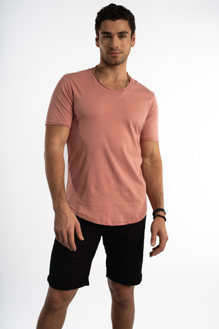 Model in a dusty rose Carbon Classic Streetwear Tee with a wide scoop neck and curved hem against a white background.