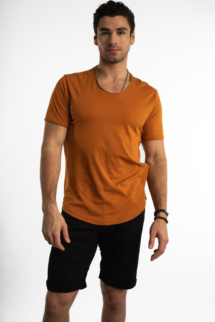 Men's Carbon Classic Streetwear Tee in burnt orange with wide scoop neck and curved hem on studio model.