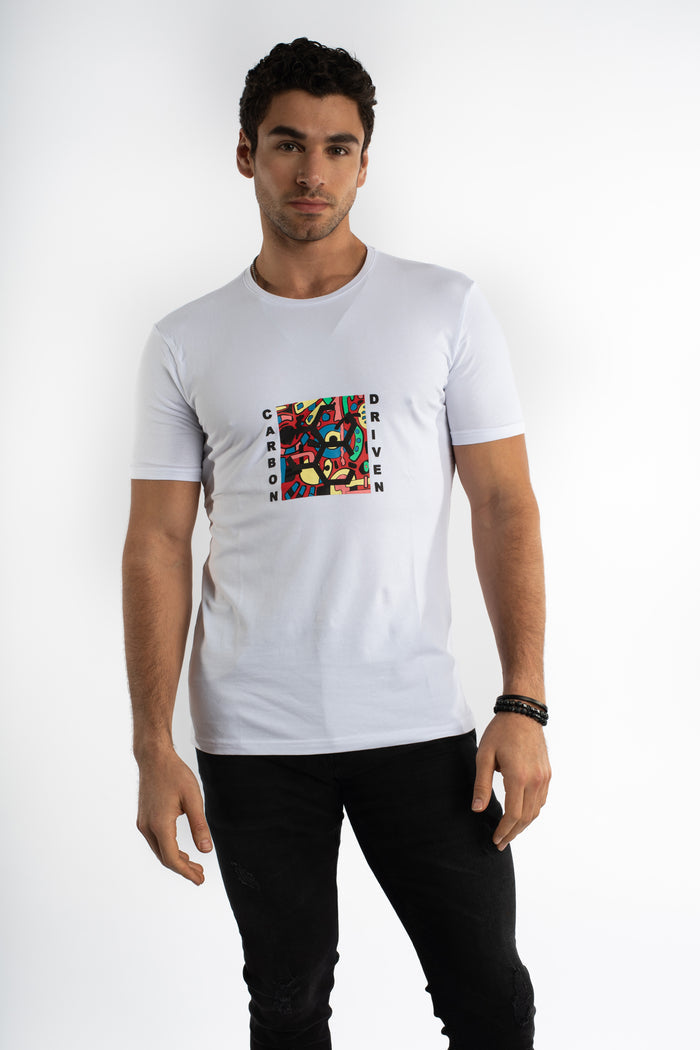 Man in a white Carbon Driven Graphic Tee with colorful chest art print and black jeans, streetwear aesthetic.