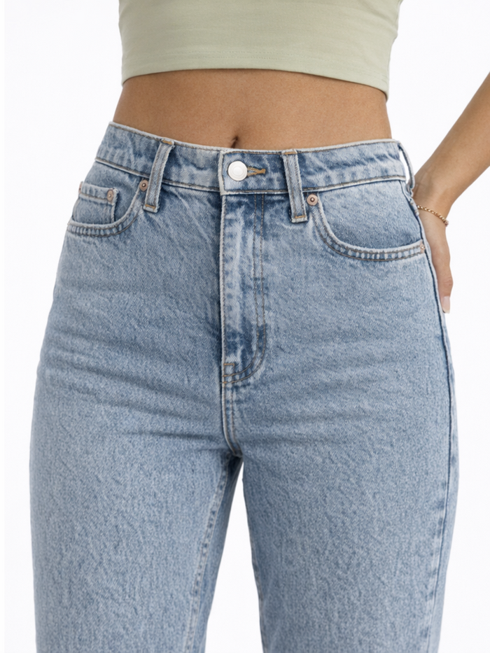 Light blue high-waisted jeans with a button closure and front pockets, styled with a cropped top.