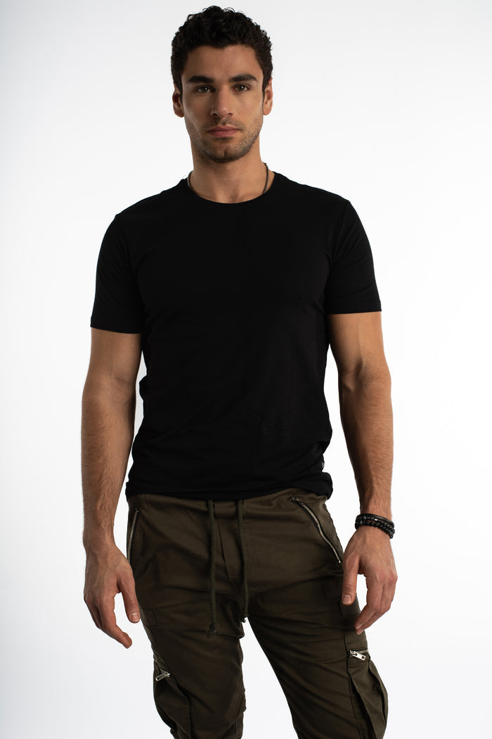 Front view of a man in a Carbon black cotton streetwear t-shirt and olive cargo pants against a white studio background.