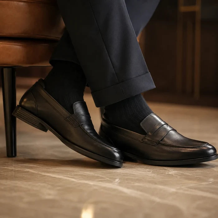 Black leather slip-on loafers with stitched apron and textured sole