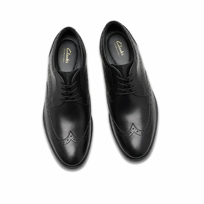 Pair of men's black leather lace-up brogue dress shoes, top view