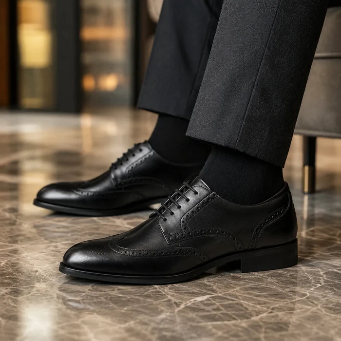 Men's black leather lace-up shoe with brogue wingtip perforations and low block heel.