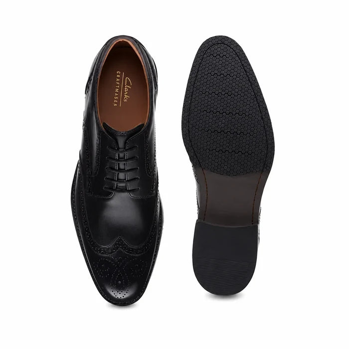 Men's black leather lace-up shoe front and outsole view, with cap-toe and brogue detailing.