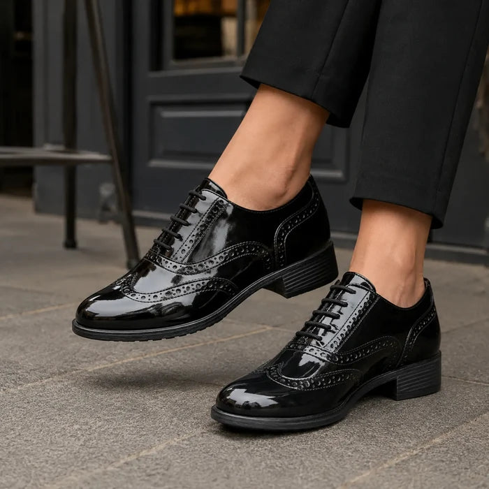 Black patent lace-up business shoes with brogue wingtip detailing and block heel
