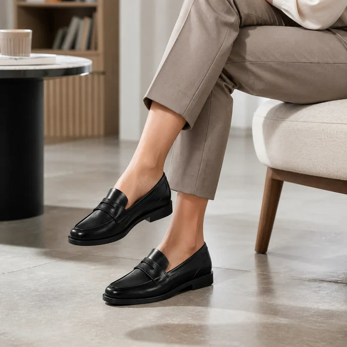 Black leather penny loafers with buckle-style strap detail and low block heel