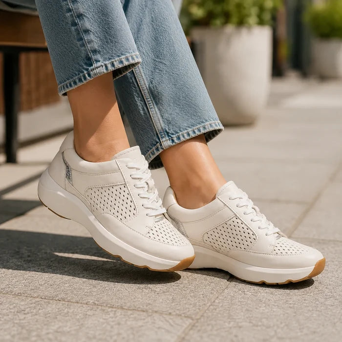 Beige leather sneakers with perforated sides, white laces, and cushioned platform sole