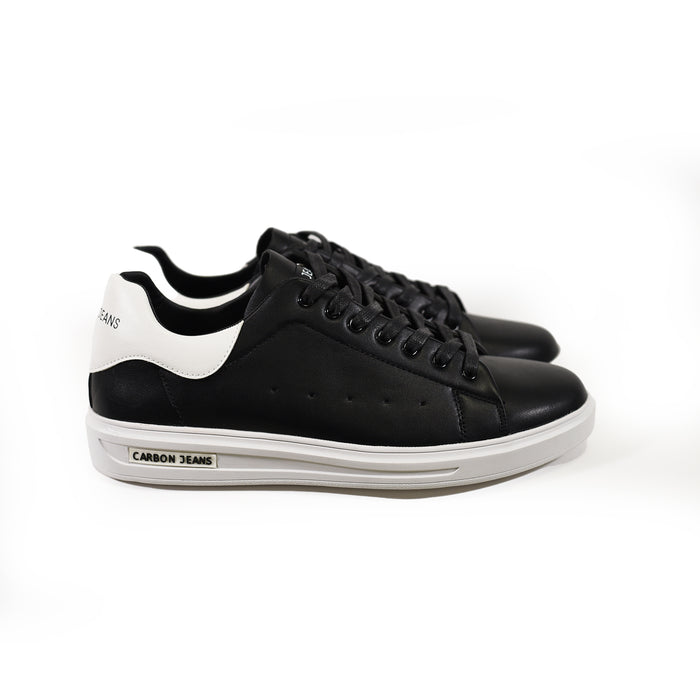 Carbon black low-top sneakers with white thick rubber soles and white heel tabs. Essential minimalist streetwear footwear.
