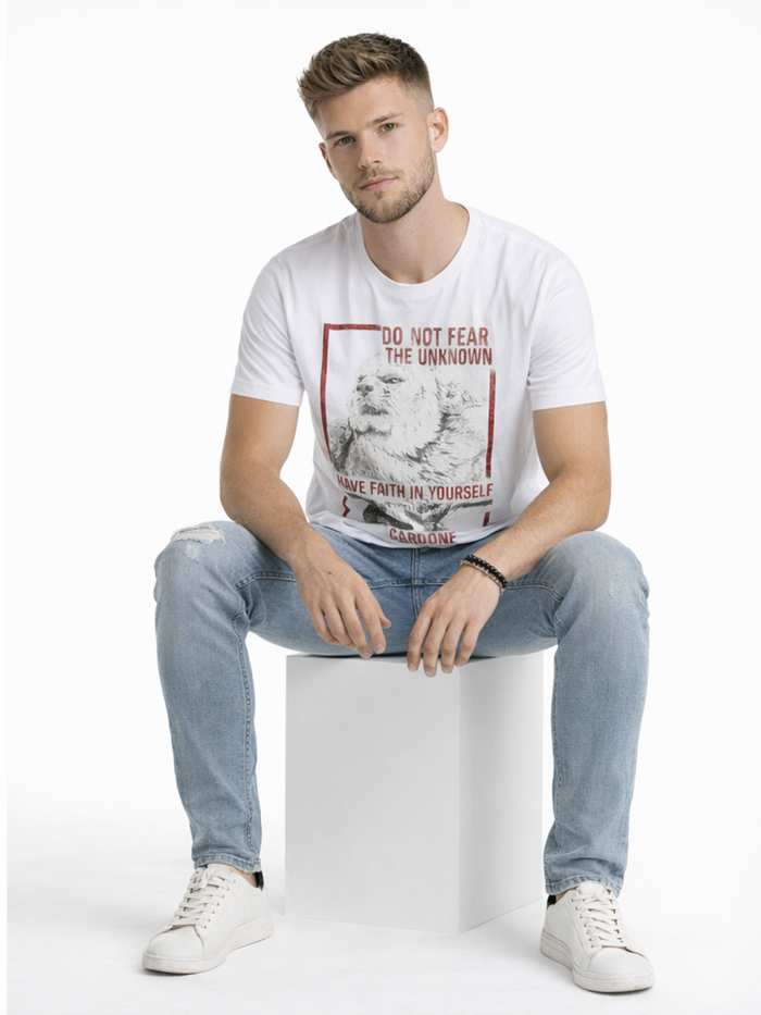 Model sitting wearing blue distressed jeans with white sneakers
