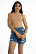 Model wearing the nude Demi Ribbed Tank Top with distressed denim shorts. High-neck essential base layer in a slim fit.