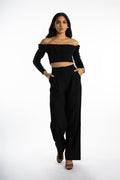 Model in Dulce black off-the-shoulder bodysuit with corset ribbing and matching wide-leg trousers streetwear.