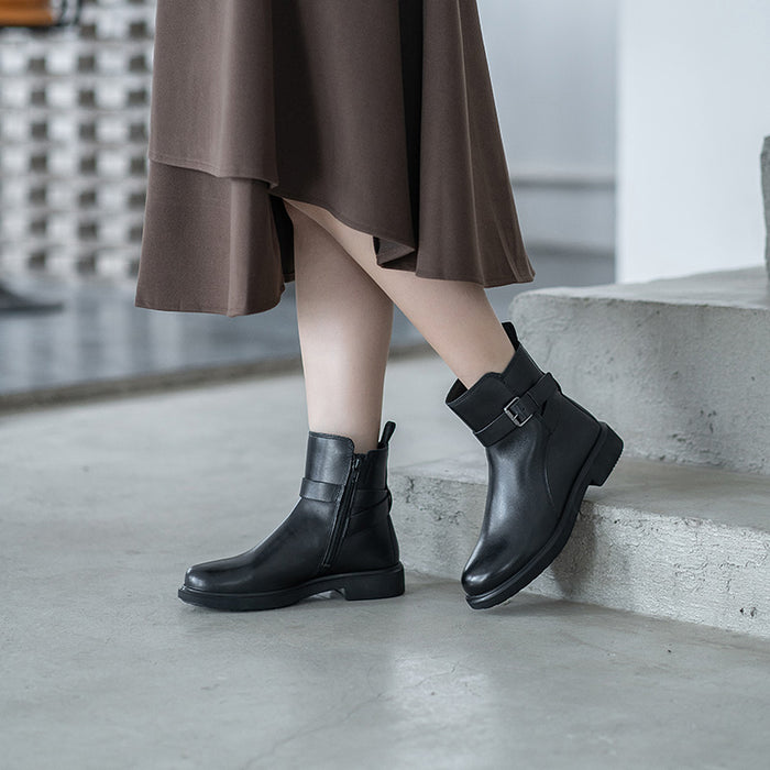 Black leather ankle boots with buckle strap worn with a long taupe dress