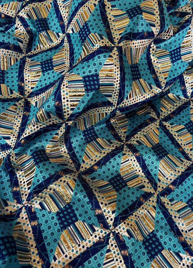 Close-up view of African Bazin Brocade Lace Fabric with a geometric pattern in royal blue, sky blue, white, and gold colors.
