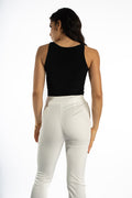 Back view of the Evie Sleeveless Bodysuit in Carbon black styled with high-waisted white trousers for a sleek OOTD.