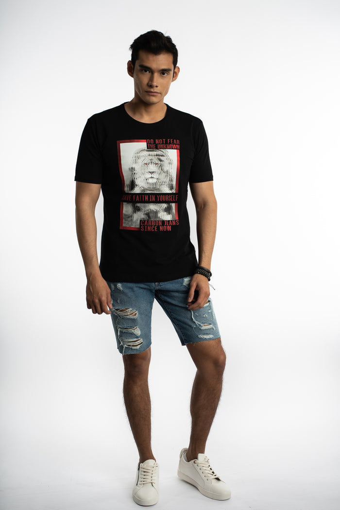 Man in a black Faith In Yourself streetwear tee with lion astronaut graphic and distressed denim shorts.