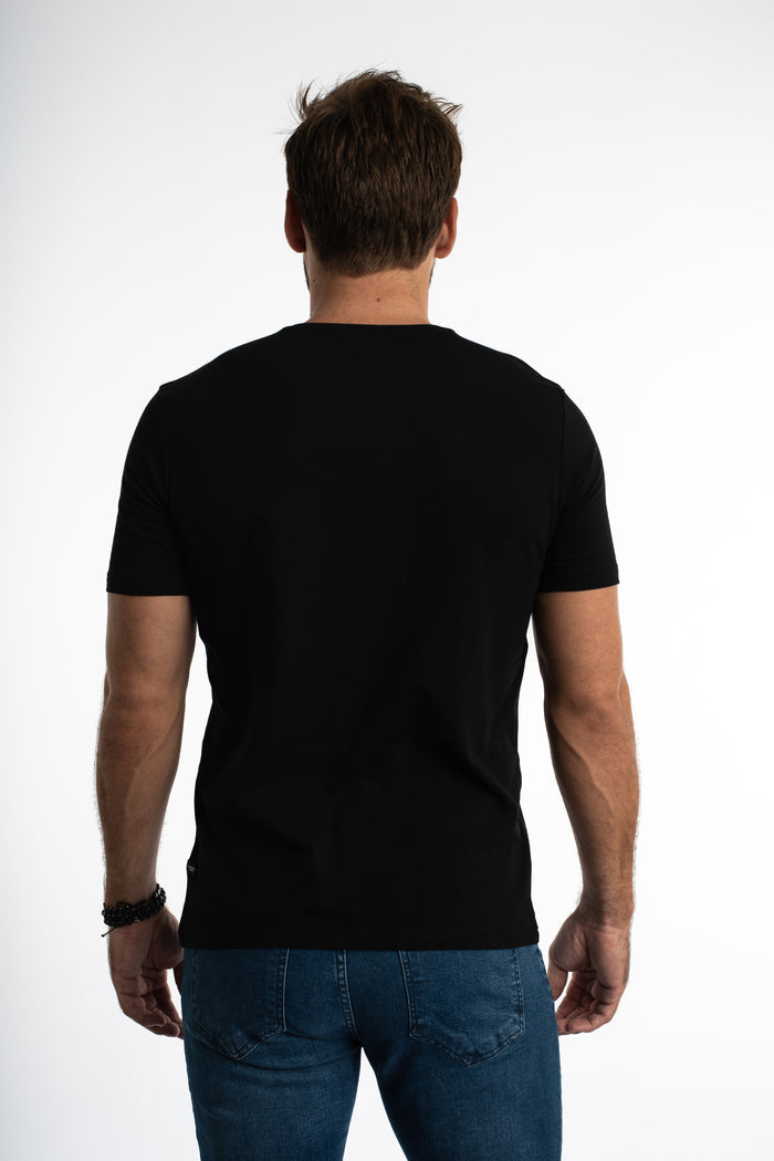 Rear view of a man in a Carbon black streetwear t-shirt with a slim fit, paired with blue jeans for an OOTD look.