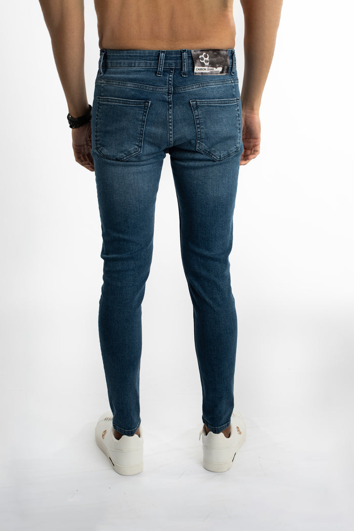 Rear view of Finnley blue denim slim fit jeans for men with back pockets and a Carbon Jeans logo patch.