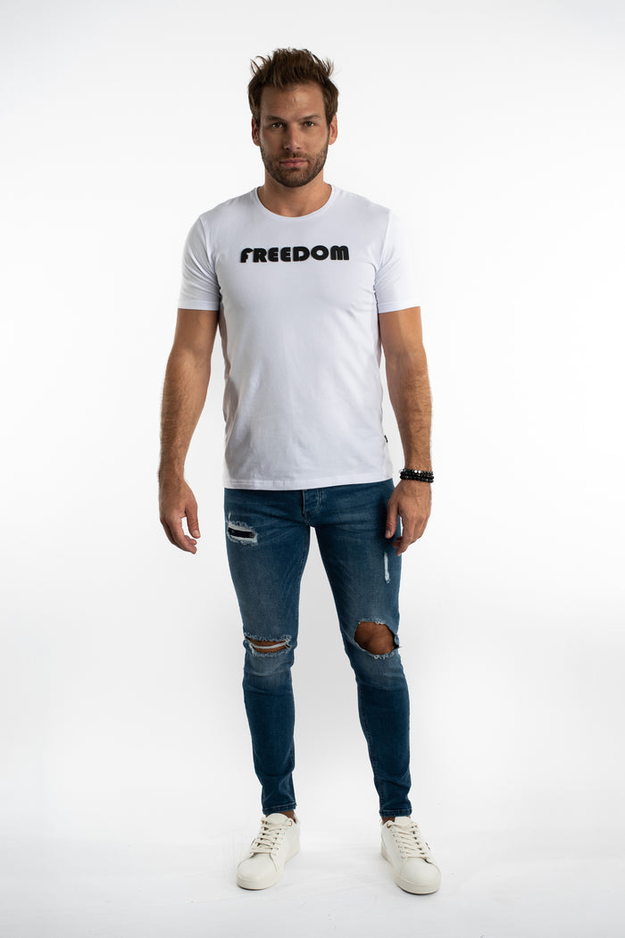 Model in Franco Men's Slim Fit Blue Denim Jeans with distressed ripped knees and a white t-shirt on a white background.