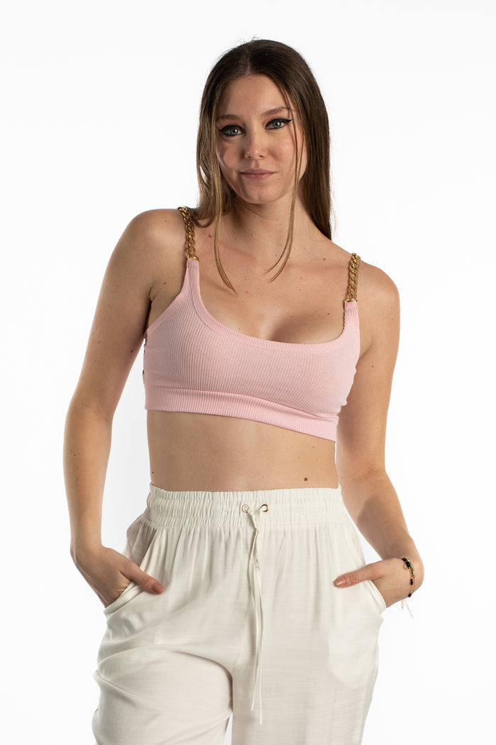 Model wearing high-waisted Freya white wide-leg pants with a drawstring and a pink ribbed crop top with gold chain straps.