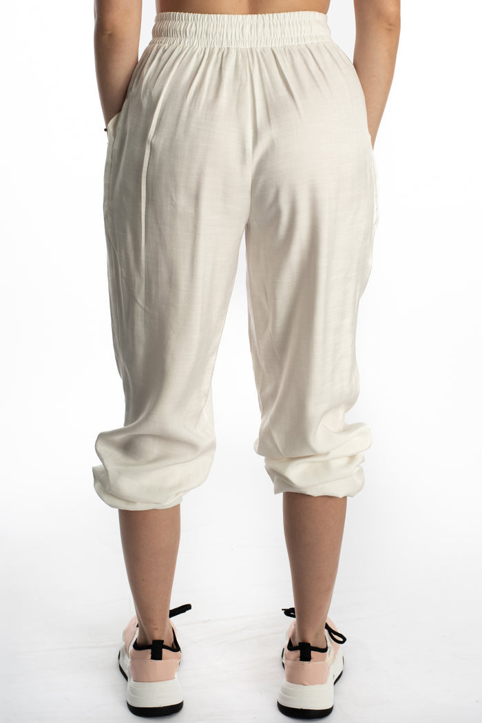 Back view of Freya white high-waisted wide-leg pants featuring a smocked elastic waistband and relaxed textured fabric.