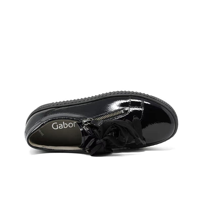 Black glossy sneaker with lace-up bow and zipper detail, side view.