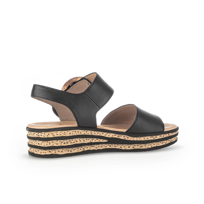 Black platform sandals with open toe, wide straps, and cork-textured sole