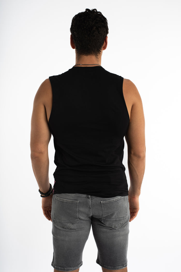 Back view of a man in the Game Over graphic streetwear tank in Carbon black, paired with grey denim shorts.