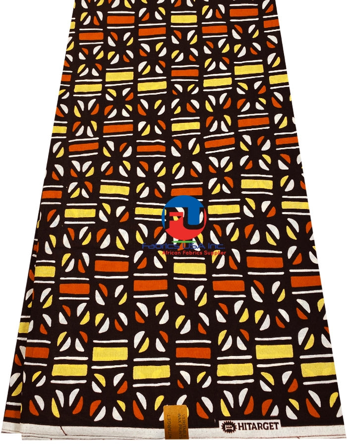 A bolt of African Ankara fabric with a geometric pattern in golden, brown, and other colors on a brown background.