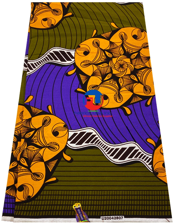 A fabric featuring an orange and purple spiral pattern on a green background, with a label showing the brand name and the text '100% Cotton'.