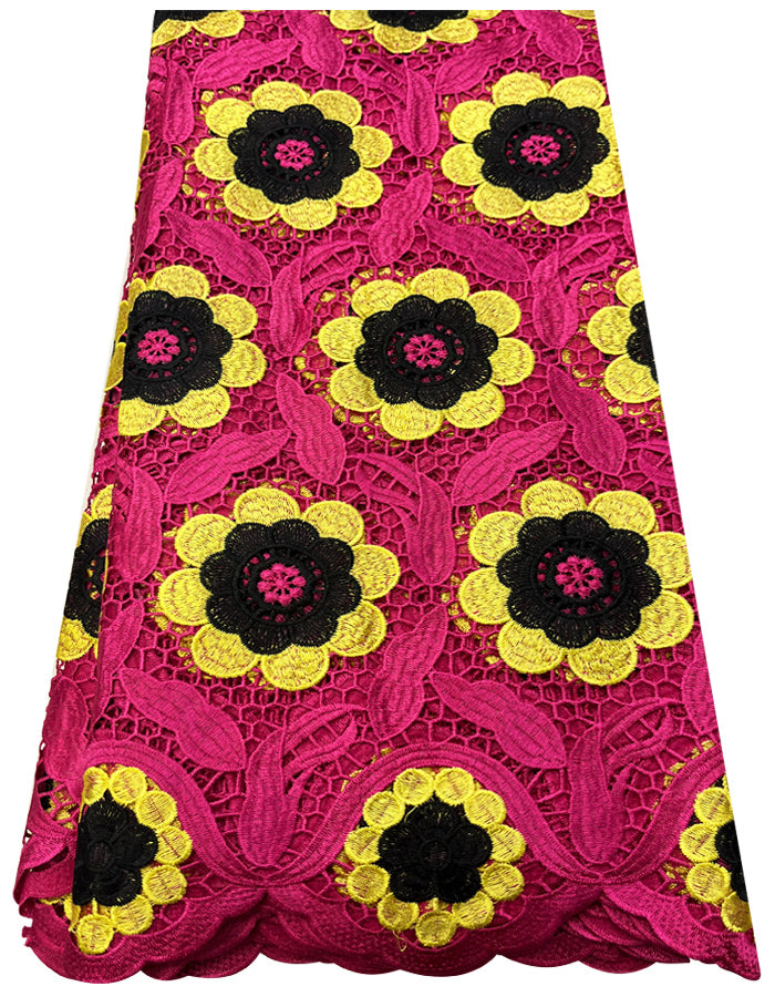 A piece of embroidered lace fabric in fuchsia pink, yellow, and black with a floral pattern.