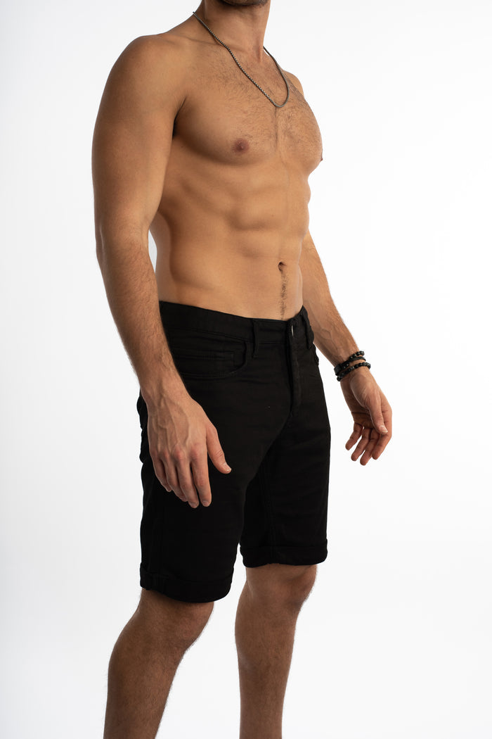 Slim fit Hank black denim shorts for men with a cuffed hem, styled as streetwear on a shirtless model.