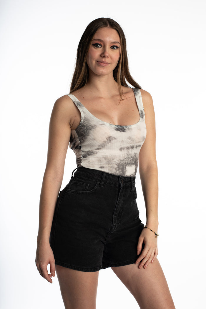Model in Harmoni seamless carbon tie-dye bodysuit and high-waisted black denim shorts, chic aesthetic OOTD.