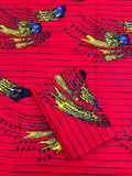 African Red fabric with black and yellow patterns on a red background