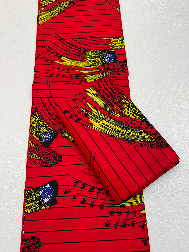 Red fabric with black, yellow, and blue abstract patterns on a white background