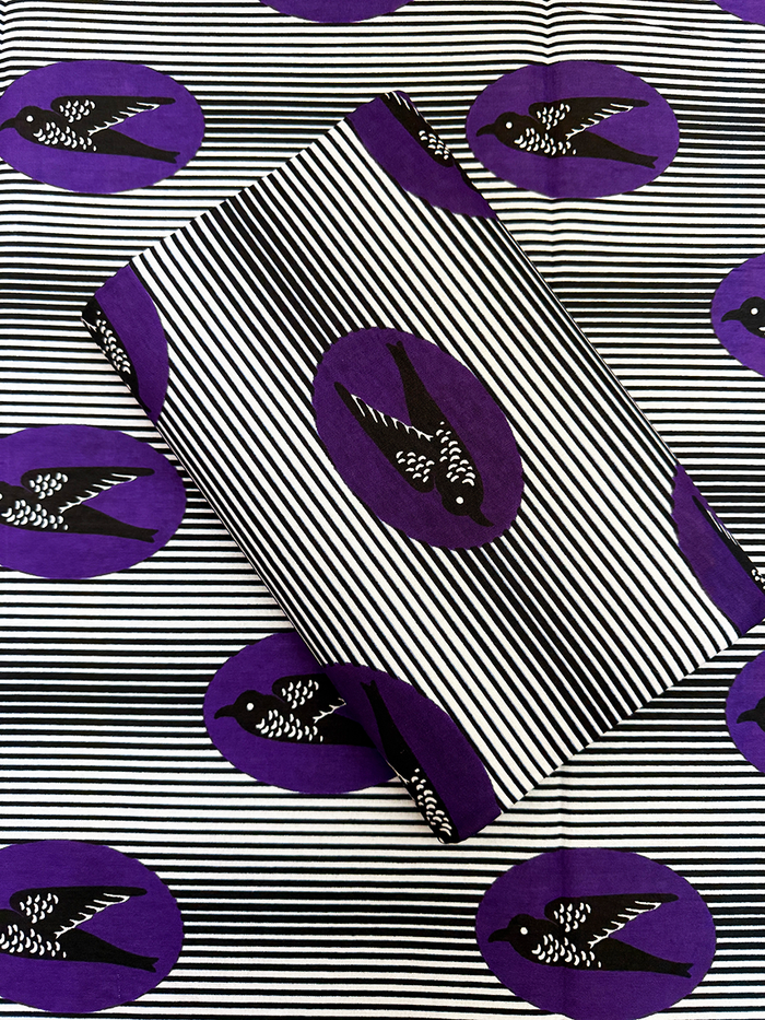 Patterned fabric with black and white stripes and purple circles featuring black birds on a white background.