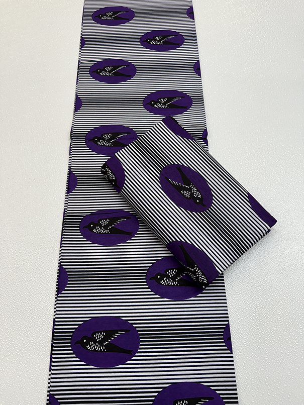Black and white striped fabric with purple circular patterns on a white background