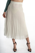 Model wearing the Jada Skirt, a white high-waisted pleated midi skirt paired with black strap heels.