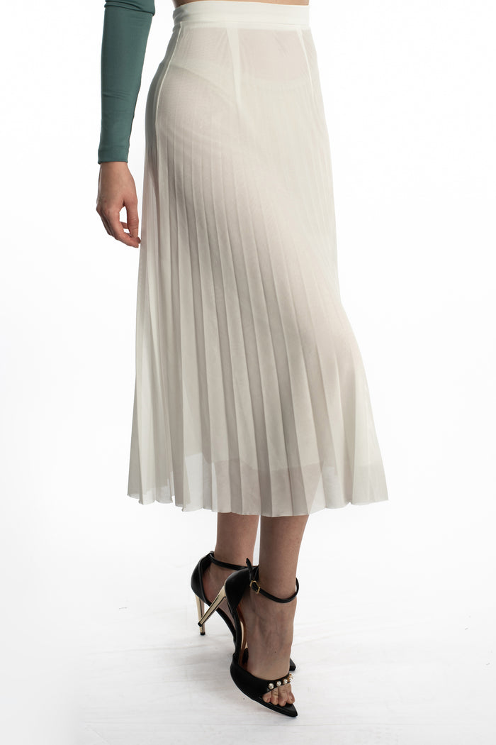White Jada high-waisted pleated midi skirt with black heels and a green long-sleeve top.